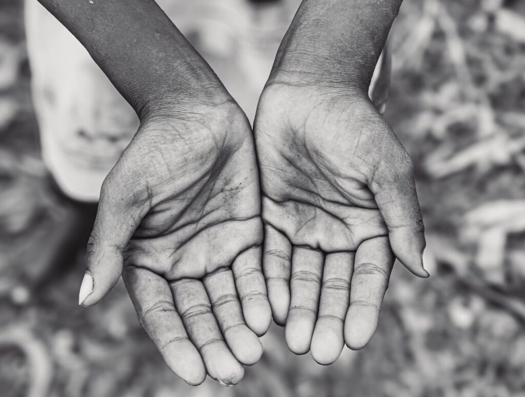 A black and white photo capturing open hands, symbolizing giving or receiving.